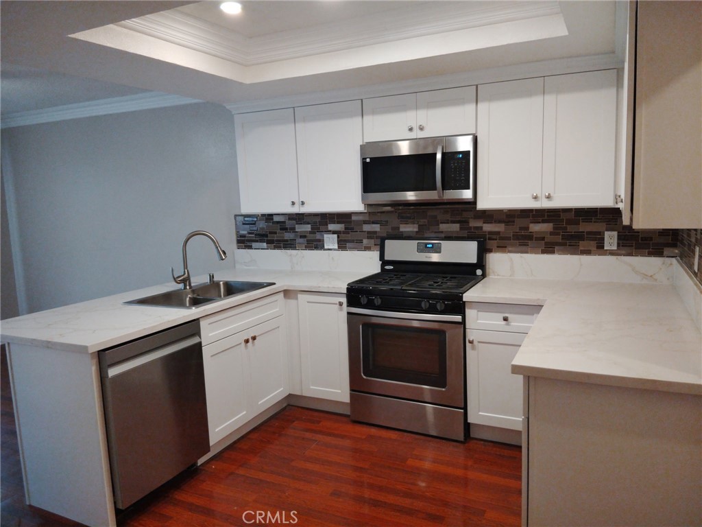 44535 La Paz Road, Unit D Temecula, CA 92592 - Photo 3 of 10 a kitchen with stainless steel appliances a stove a microwave sink and cabinets