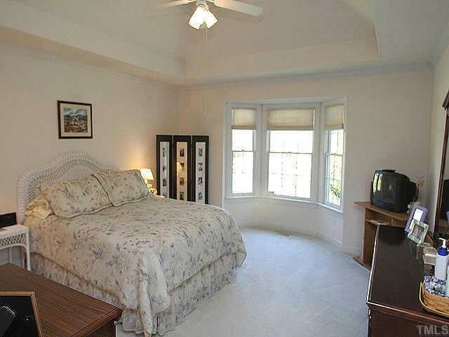 5200 Thorpe Drive Raleigh, NC 27613 - Photo 8 of 10 a bedroom with a large bed and a flat tv screen on a dresser