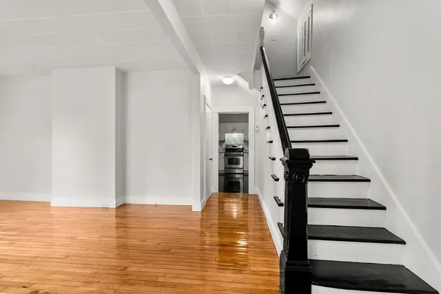 a view of entryway and hall with wooden floor