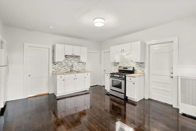 a kitchen with a refrigerator stove and white cabinets