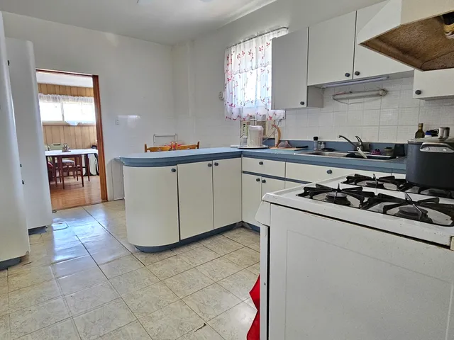 a kitchen with a sink a stove and cabinets