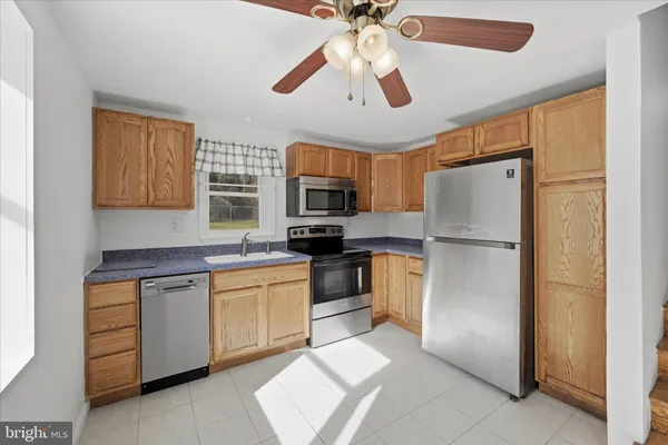 a kitchen with stainless steel appliances granite countertop a refrigerator a stove top oven a sink and dishwasher