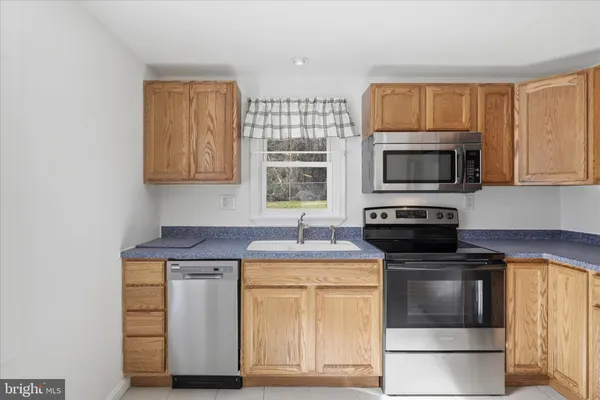 a kitchen with stainless steel appliances granite countertop a refrigerator a stove a sink a washer and dishwasher