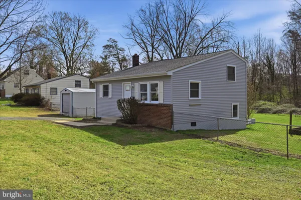 a view of a house with backyard and a tree
