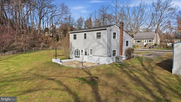 a view of a house with backyard and trees