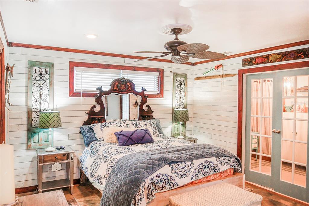 4380 Benview Avenue Weeki Wachee, FL 34607 - Photo 29 of 56 a bedroom with a large bed and a chandelier