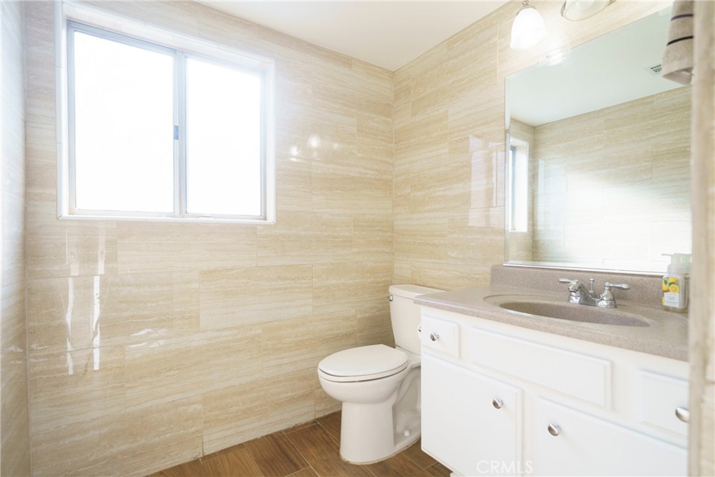 43922 Fallon Drive Lancaster, CA 93535 - Photo 23 of 36 a bathroom with a granite countertop toilet a sink a mirror and a window