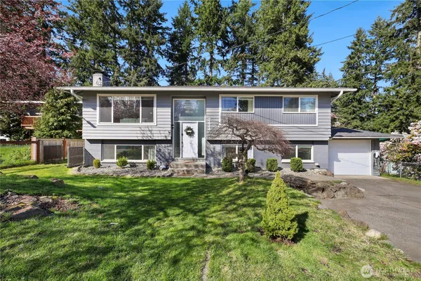 a front view of a house with a garden and plants