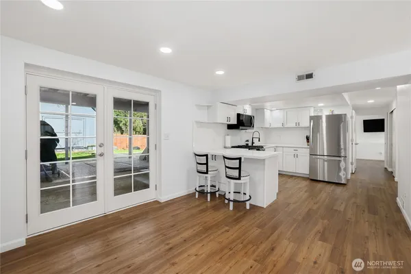 a view of a kitchen with dining space wooden floor and a large window