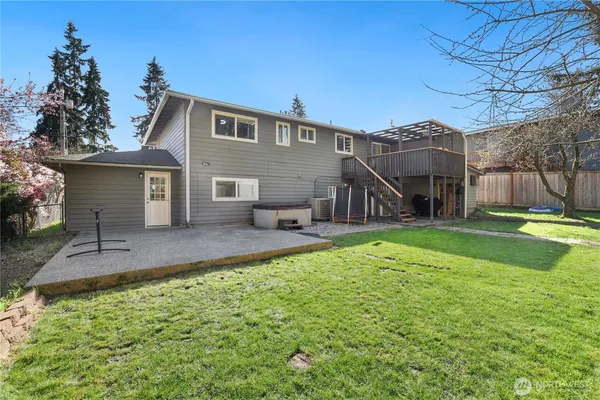 a view of a house with backyard and a tree
