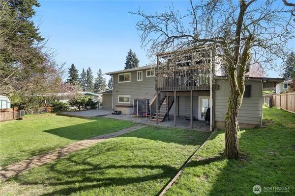 a house view with a play ground and a large tree