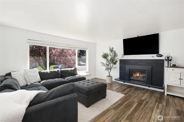 a living room with furniture a flat screen tv and a fireplace