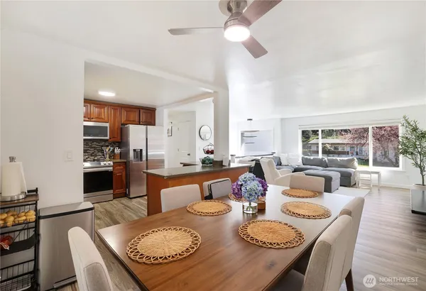 a dining room with furniture a large window and a chandelier