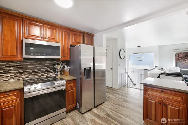a kitchen with stainless steel appliances granite countertop a refrigerator stove and sink