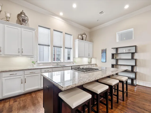 a kitchen with granite countertop a sink and a stove top oven