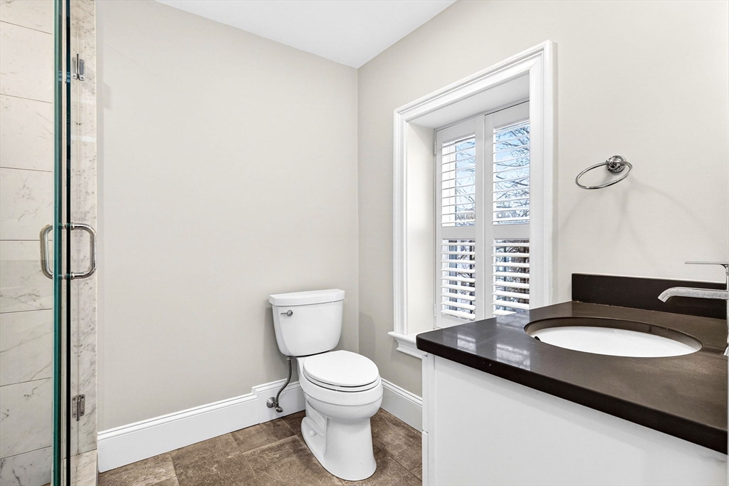 137 N Street, Unit 3 Boston, MA 02127 - Photo 18 of 28 a bathroom with a granite countertop sink toilet a mirror and shower