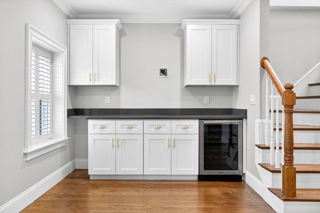 137 N Street, Unit 3 Boston, MA 02127 - Photo 10 of 28 a kitchen with stainless steel appliances granite countertop a stove a sink and white cabinets with wooden floor