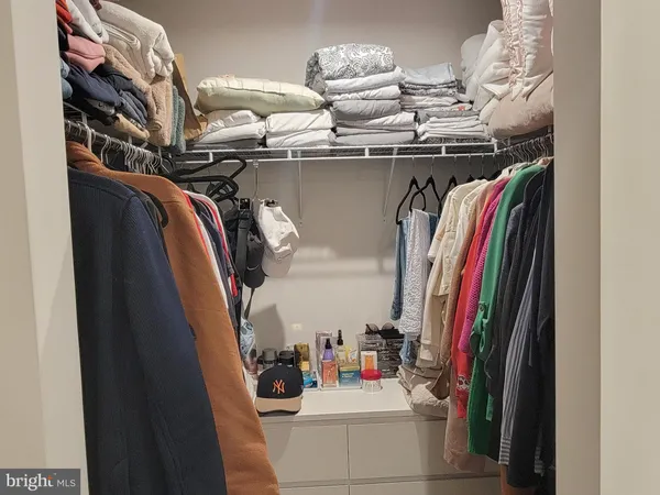 a view of walk in closet with clothes and shoes