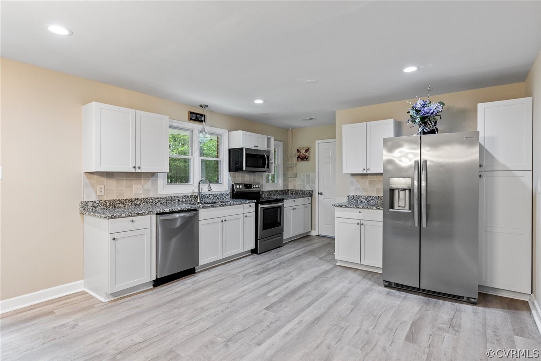 6286 McClellan Road Mechanicsville, VA 23111 - Photo 7 of 29 a kitchen with granite countertop a refrigerator and a stove top oven