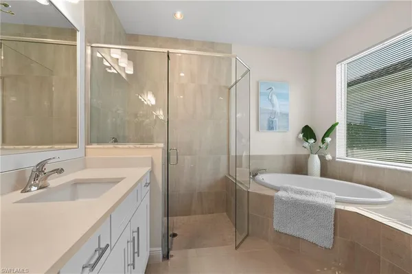 a bathroom with a granite countertop sink a mirror a shower and a bathtub