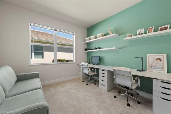 a view of a workspace with furniture and a window