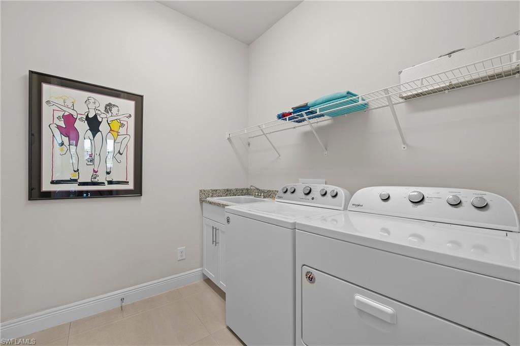 8897 Redonda Drive Naples, FL 34114 - Photo 27 of 42 Washroom with light tile patterned floors, washer and dryer, and cabinet space