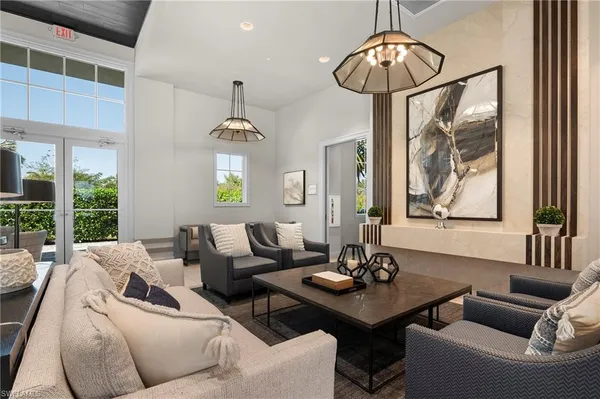 a living room with furniture a chandelier and a window
