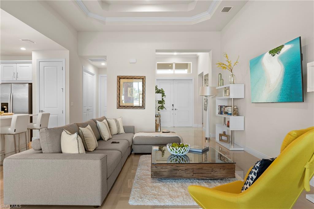 8897 Redonda Drive Naples, FL 34114 - Photo 9 of 42 Living area with a raised ceiling and baseboards
