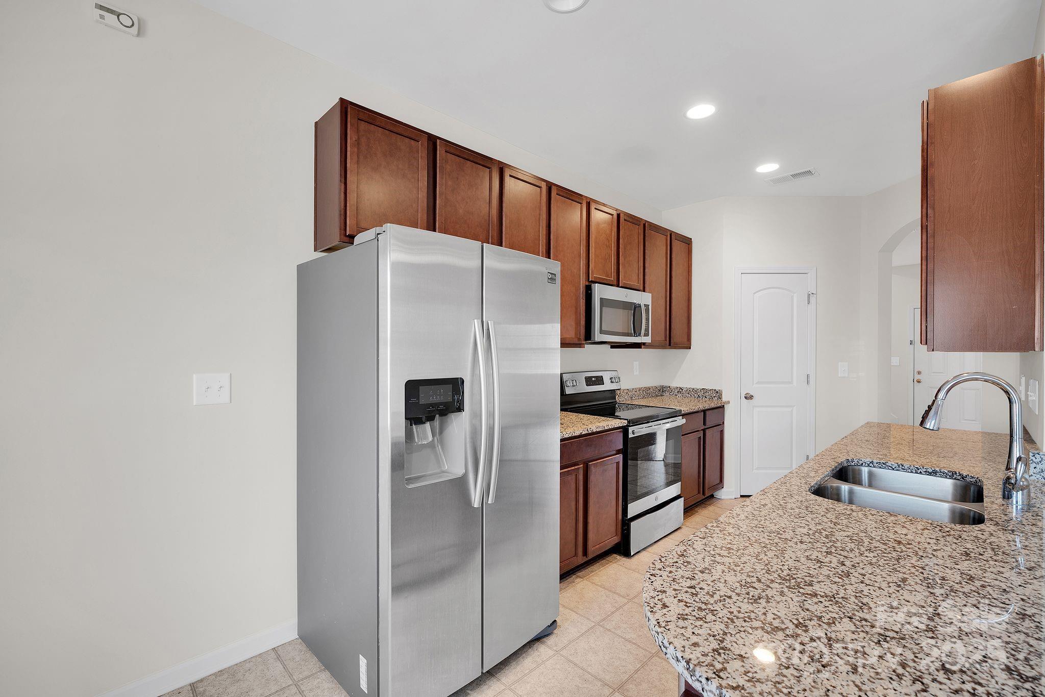 6439 Prosperity Church Road Charlotte, NC 28269 - Photo 18 of 46 a kitchen with stainless steel appliances granite countertop a refrigerator and a sink