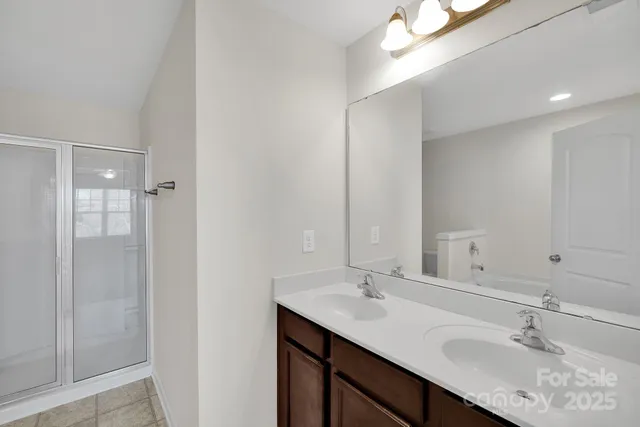 a bathroom with a sink double vanity and shower