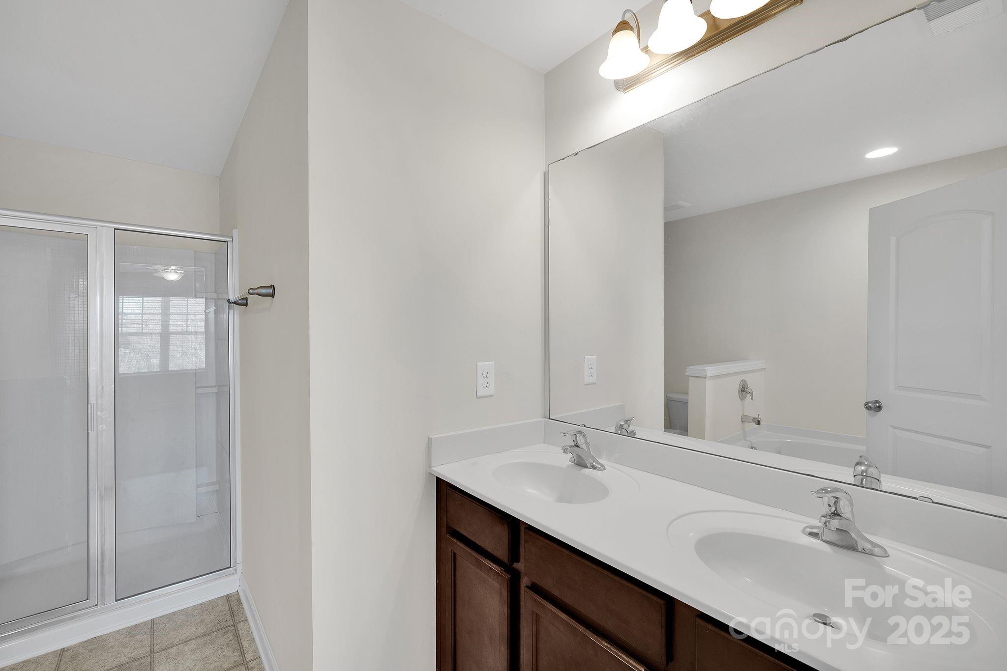 6439 Prosperity Church Road Charlotte, NC 28269 - Photo 19 of 46 a bathroom with a sink double vanity and shower