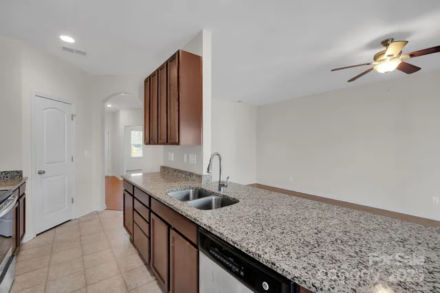 a kitchen with stainless steel appliances granite countertop a sink dishwasher and refrigerator