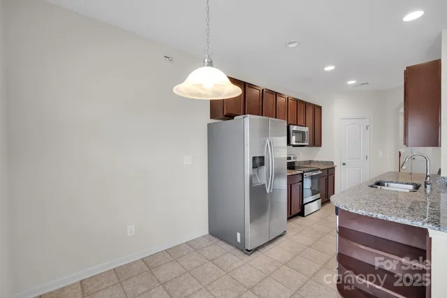 a kitchen with stainless steel appliances granite countertop a refrigerator and a sink