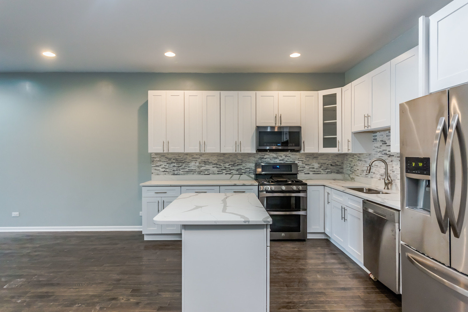 352 North Avers Avenue Chicago, IL 60624 - Photo 7 of 18 a kitchen with stainless steel appliances granite countertop a stove top oven a sink and a refrigerator