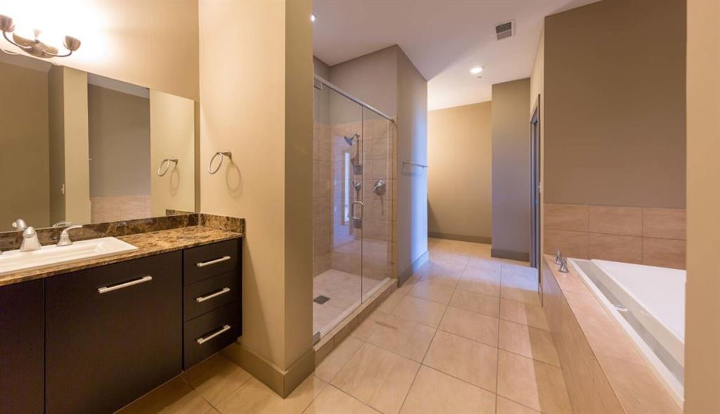 2171 Peachtree Road, Unit 1403 Atlanta, GA 30309 - Photo 9 of 25 a bathroom with a granite countertop sink a mirror and a bathtub