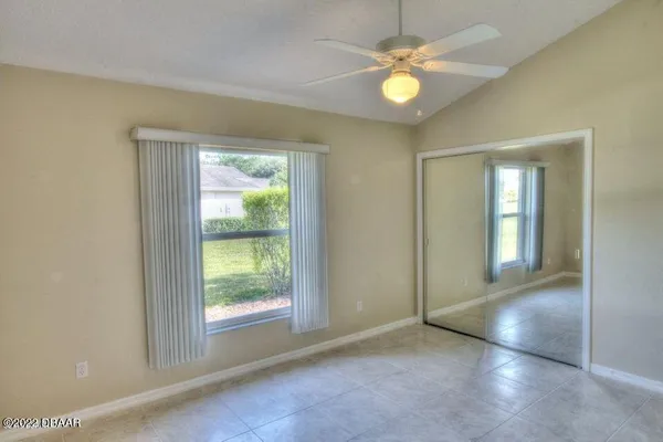 an empty room with windows and fan