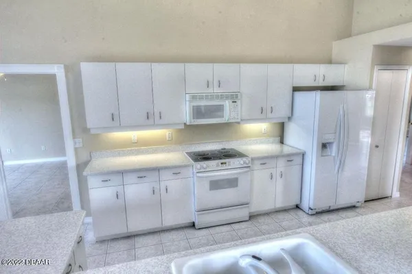 a kitchen with granite countertop white cabinets and stainless steel appliances