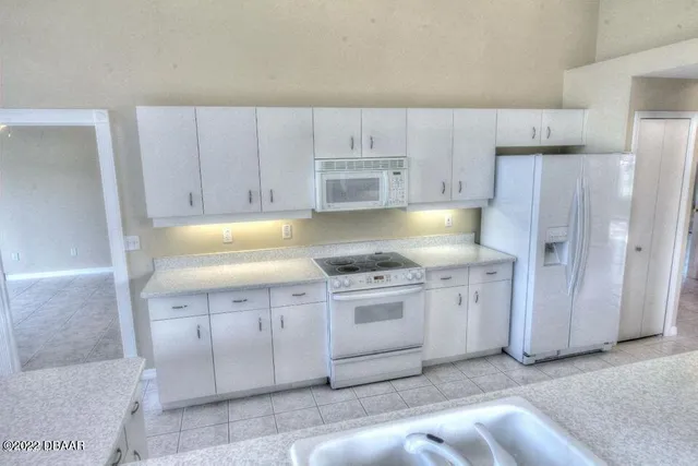 a kitchen with granite countertop white cabinets and stainless steel appliances