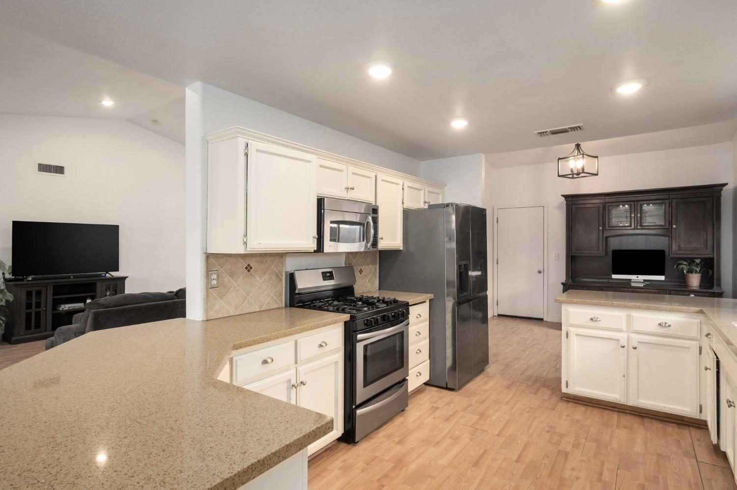 372 Lily Avenue Sanger, CA 93657 - Photo 11 of 30 a kitchen with stainless steel appliances a stove a sink a microwave a refrigerator and cabinets