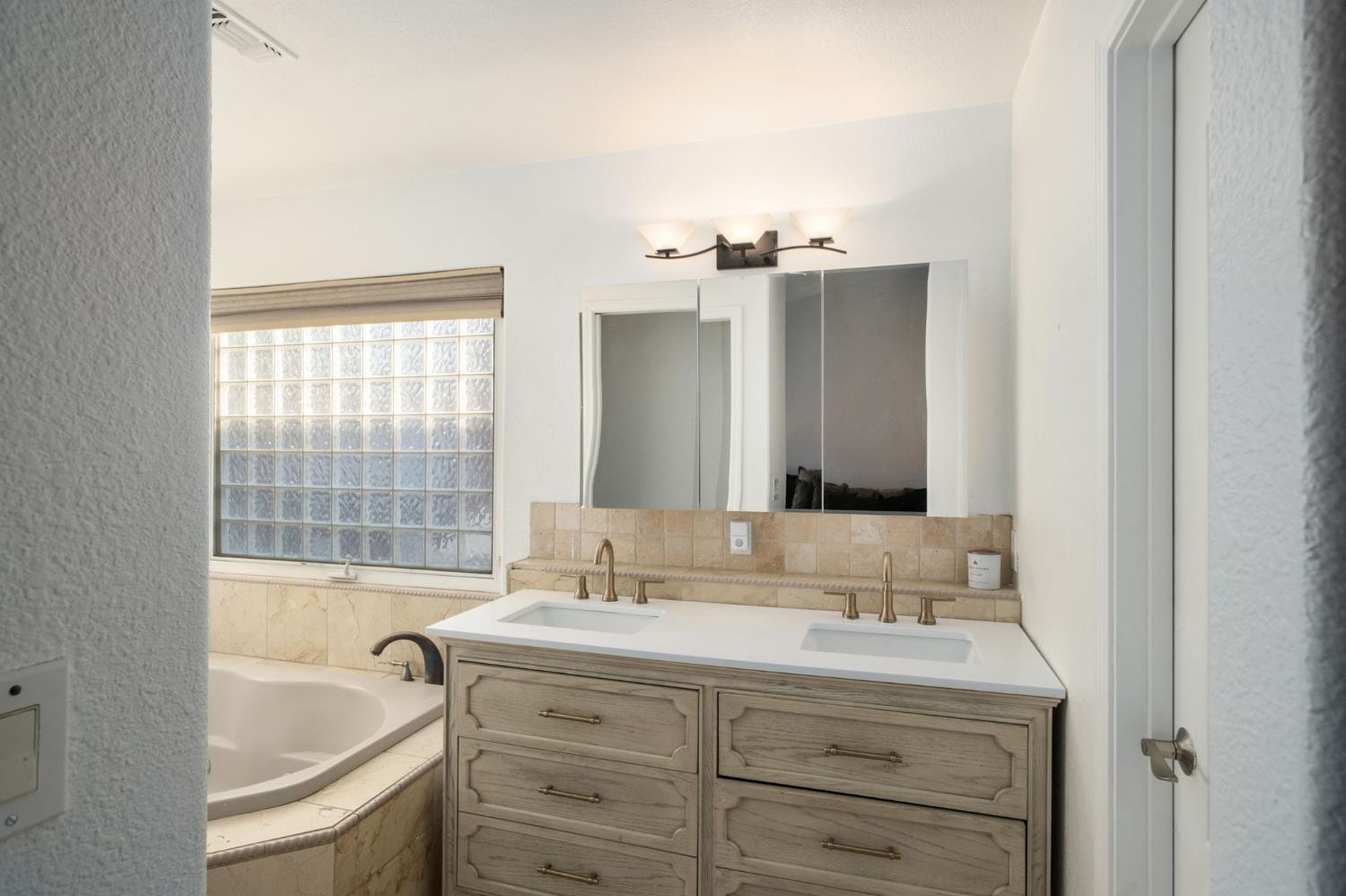 372 Lily Avenue Sanger, CA 93657 - Photo 15 of 30 a bathroom with a tub sink and mirror