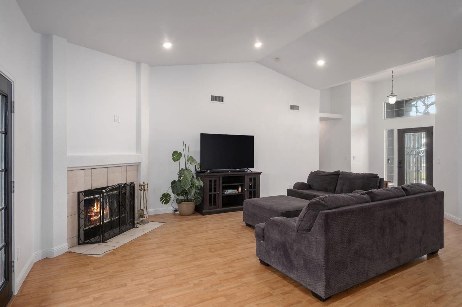 372 Lily Avenue Sanger, CA 93657 - Photo 6 of 30 a living room with furniture a flat screen tv and a fireplace