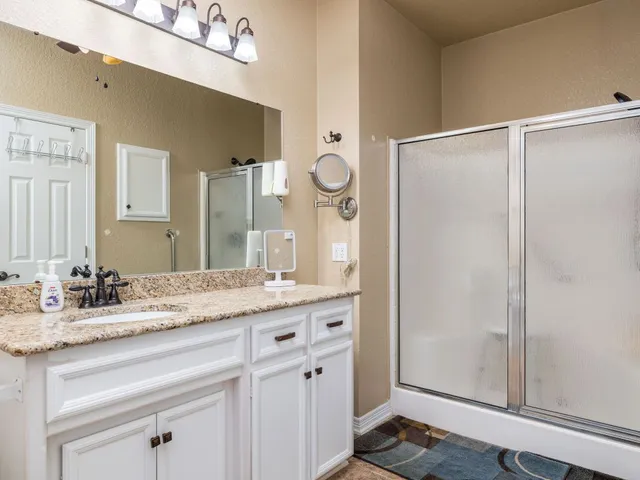 a bathroom with a granite countertop sink and a mirror