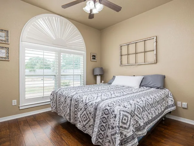 a bedroom with a large bed and a chandelier