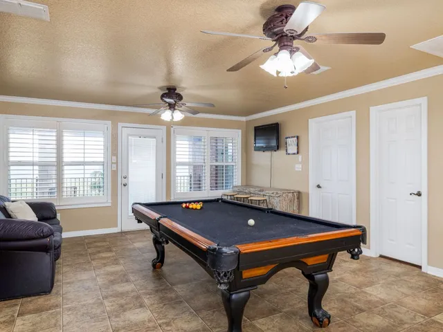 a pool table sitting in a room next to a window