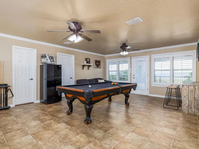 a room with pool table and windows