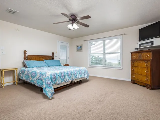 a bedroom with a bed and a tv on the dresser