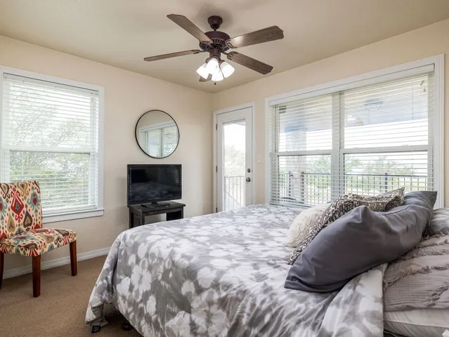 a bed sitting in a bedroom next to a window with a large bed and a large window