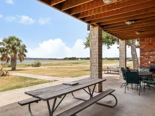 a view of a swimming pool with a table and chairs under an umbrella