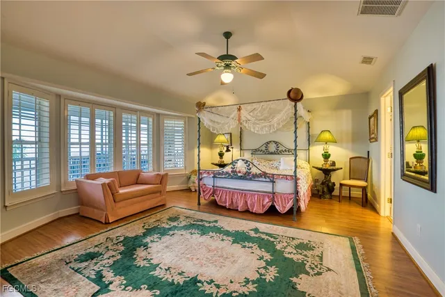 a bed sitting in a spacious bedroom next to a window