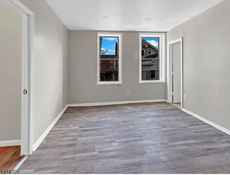 84 Second Street, Unit 4 Elizabeth Port, NJ 07206 - Photo 2 of 16 a view of an empty room with wooden floor and windows